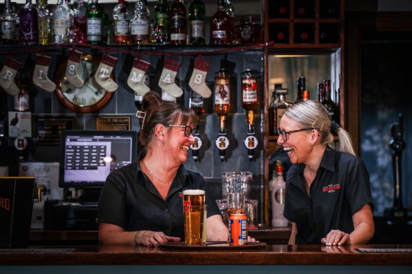 Carol-Anne Key and her colleague Sarah Cooper at The Red House Hotel's bar, with a tray of a pint and a can of Irn Bru.
