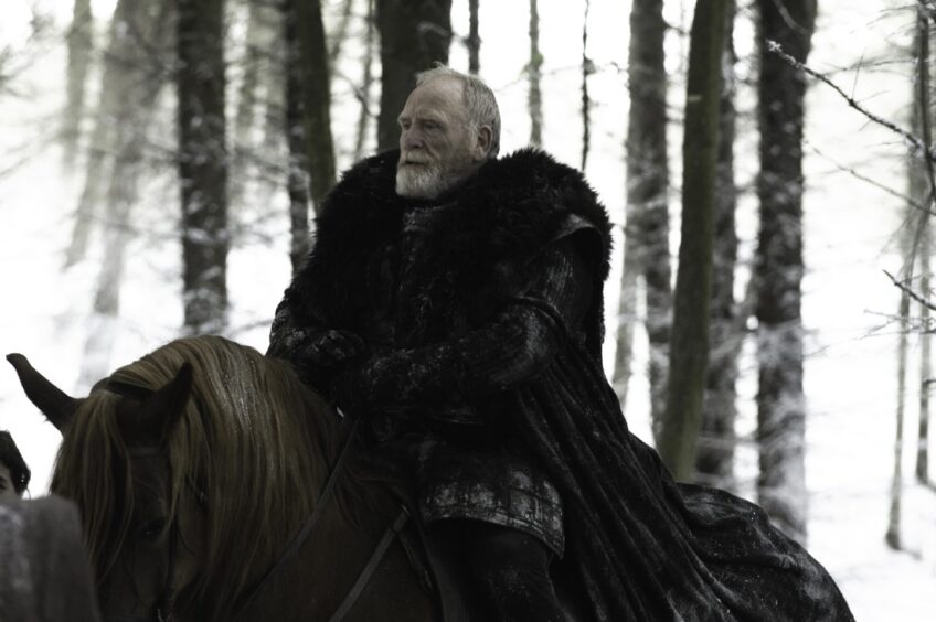 James Cosmo in furs on a horse in Game of Thrones TV show.
