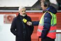 Dundee United boss Jim Goodwin is interviewed pitch-side at Pittodrie. Image: SNS