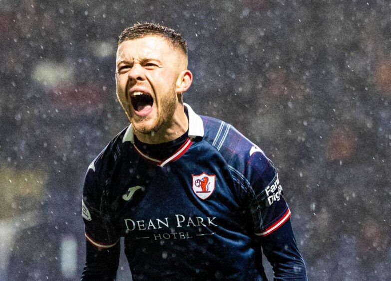 Raith Rovers striker Callum Smith roars in delight after scoring his equaliser against Partick Thistle in the rain.