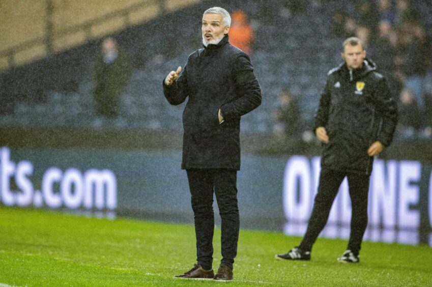 Dundee United boss Jim Goodwin looks on in the teeming Glasgow rain