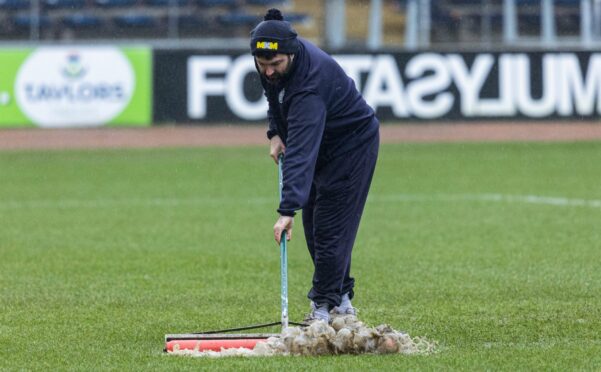 Dundee groundsman Brian Robertson works on the Dens Park pitch. Image: SNS
