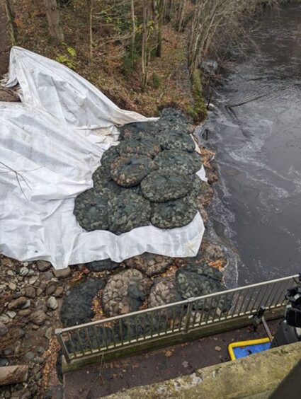 Large rock sacks beside missing stretch of riverbank beneath A9 underpass