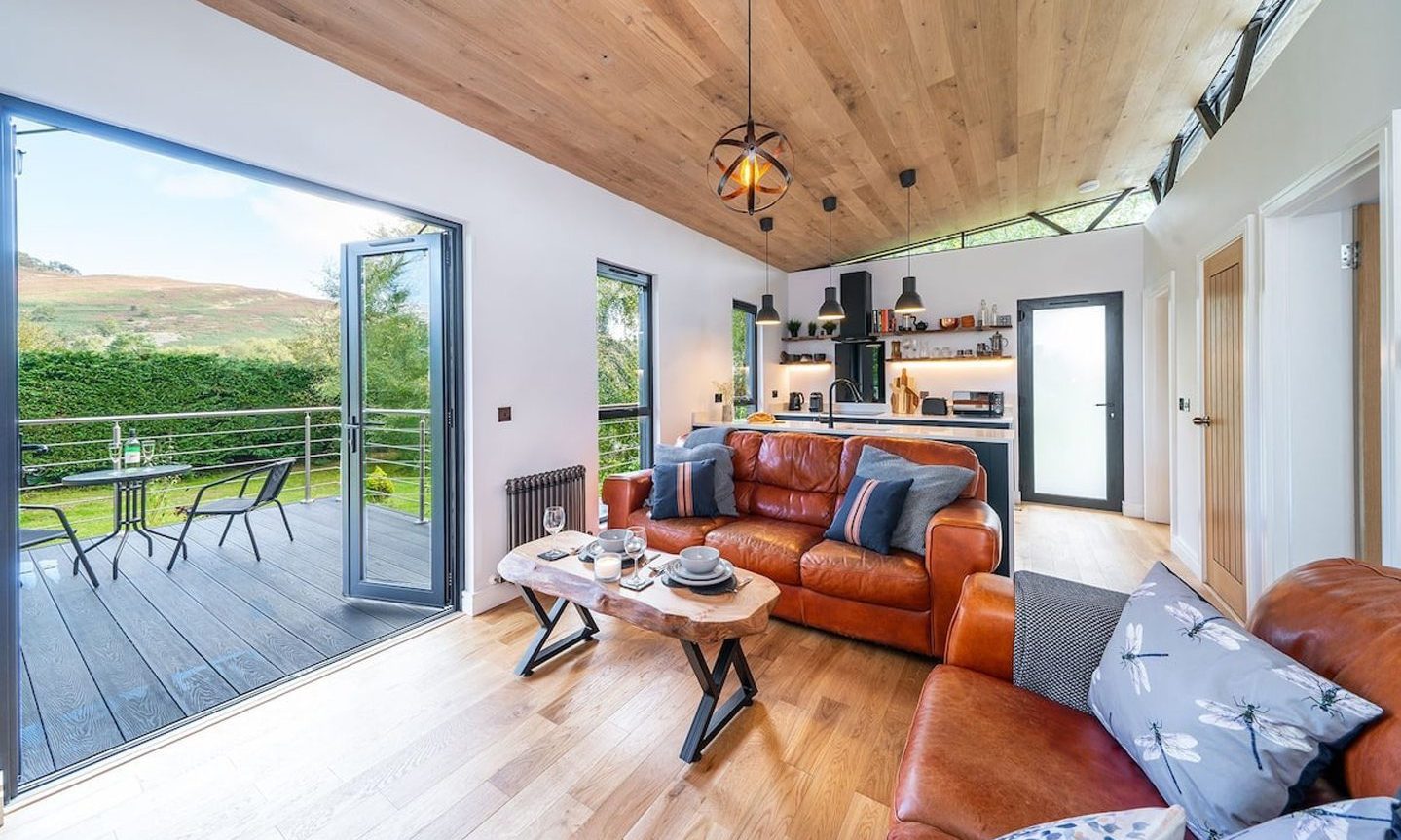 Cosy living area plus kitchen in the Angus Airbnb with patio doors onto a large, enclosed balcony.