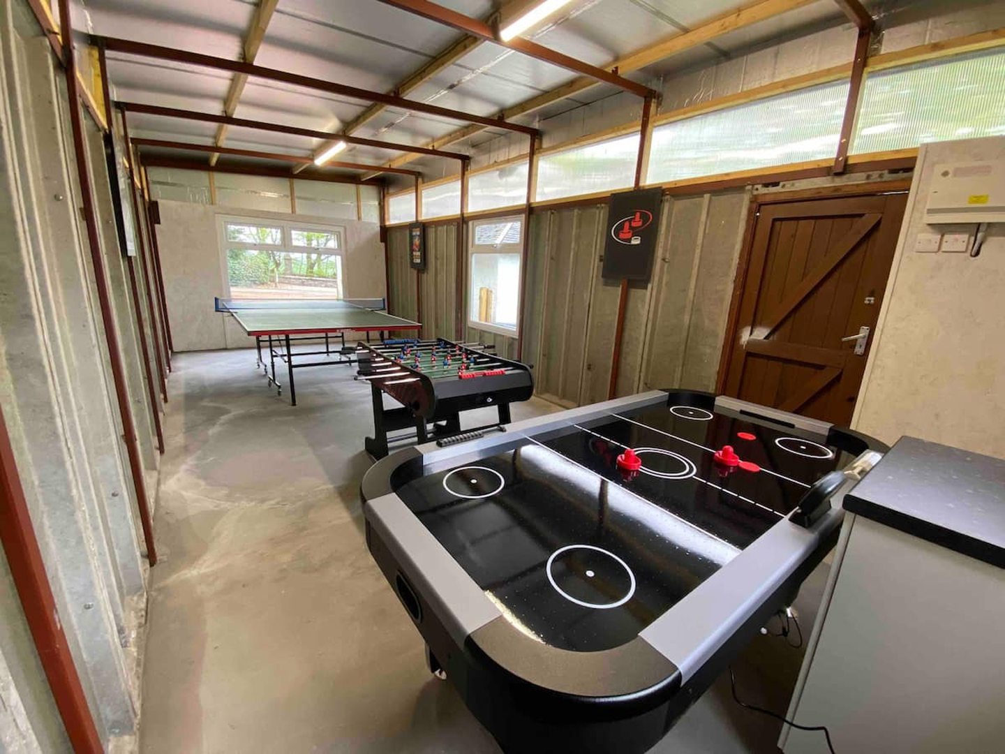 Large games room with table tennis, foosball and air hockey tables.