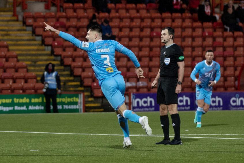 Josh Edwards points with his left arm after scoring for Dunfermline Athletic FC.