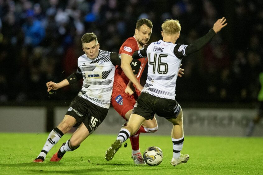 Dunfermline skipper Kyle Benedictus tussled with two opponents in the 2-2 draw against Ayr United on December 30. Image: Craig Brown / DAFC.