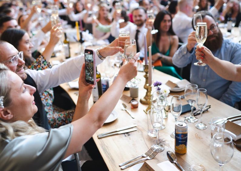 Large party with guests raising their glasses.