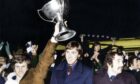 Gordon Wallace lifts the trophy high as the team return from Hampden. Image: DC Thomson/Retro Dundee.