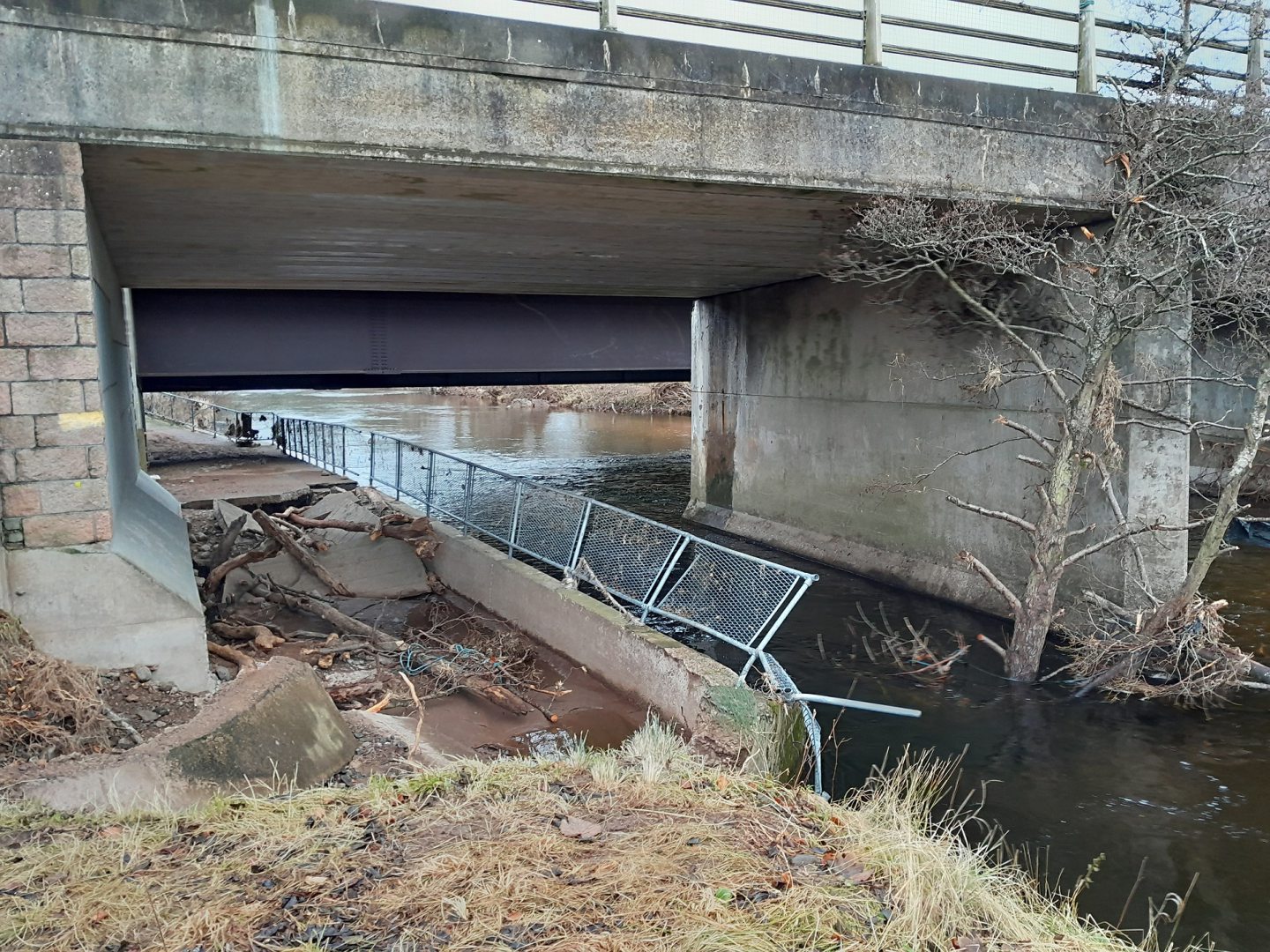 Damage to the bridge's walkway due to the high river levels.