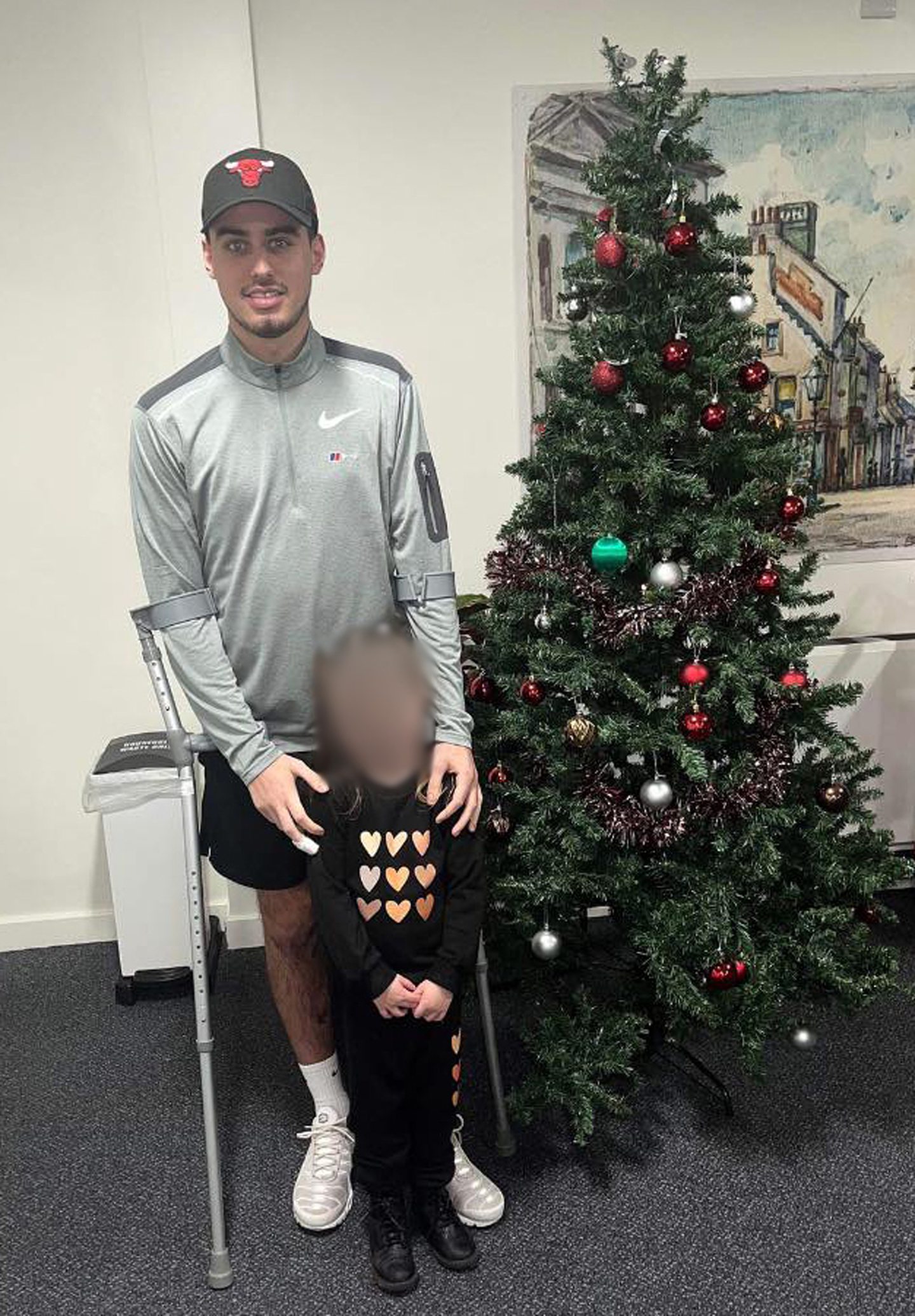 Jordan, with his child in front of a Christmas tree.