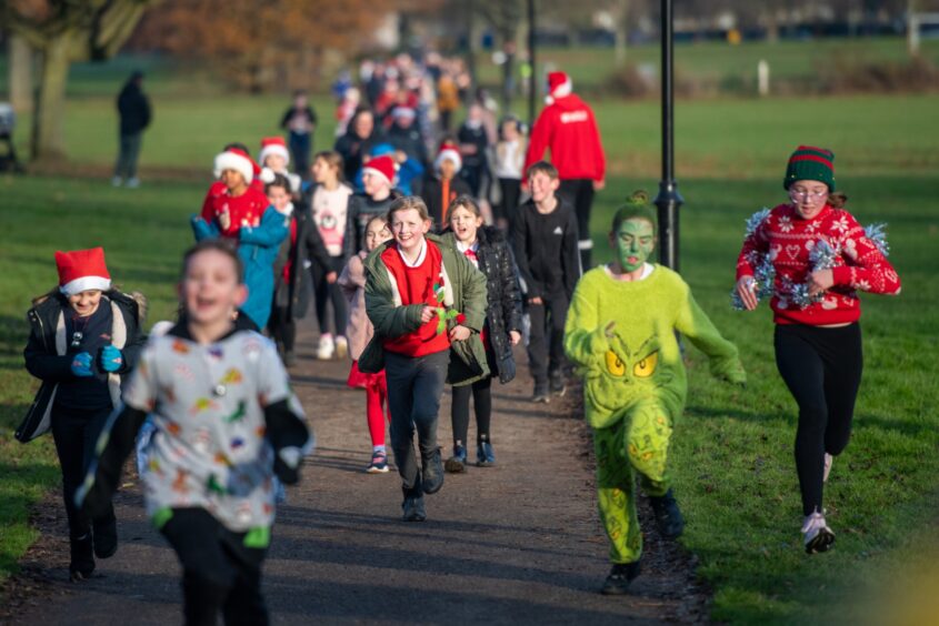 Group of children, one in Grinch costume on the Inch View primary Santa run