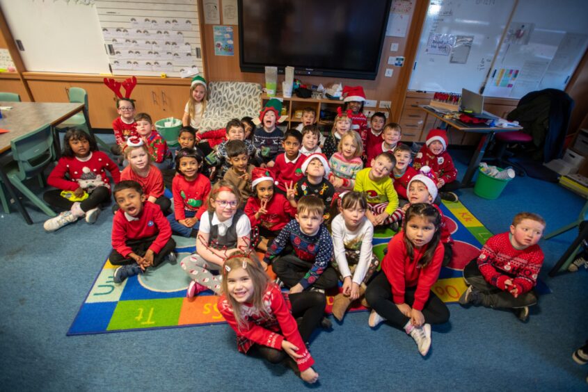 Group of P2 pupils in Santa hats and reindeer antlers