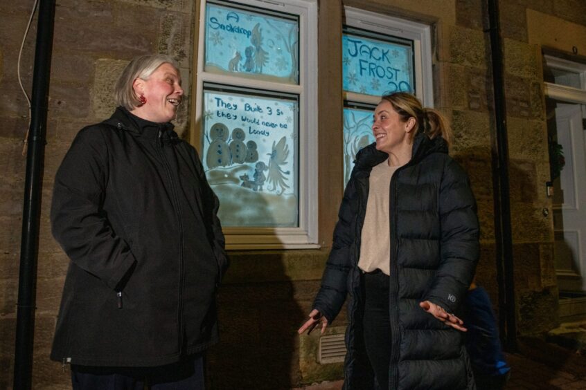 Jaime Lidstone and Charlotte Gunnion standing in front of a window with a Jack Frost theme