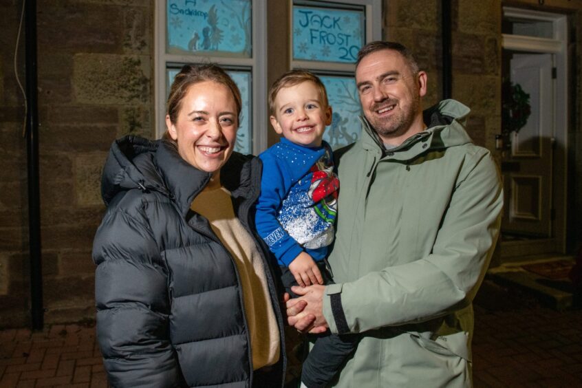 Charlotte, Jack, 3, and Ross Gunnion smiling outside their window in the Craigie area of Perth