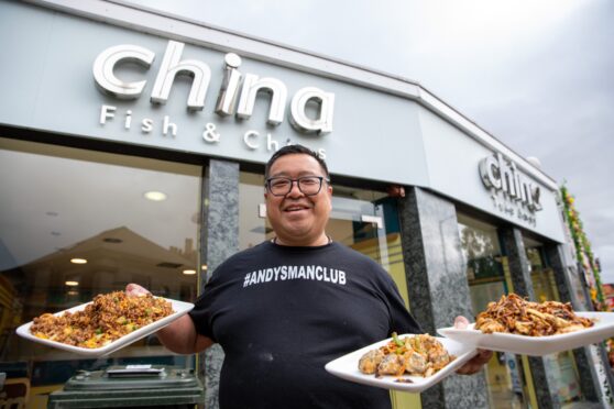 Pete Chan holding plates of food outside his China China premises in Perth.