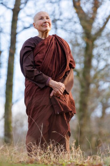 Buddhist nun Sister Candasiri wandering through the woodland sanctuary at Milntuim. 