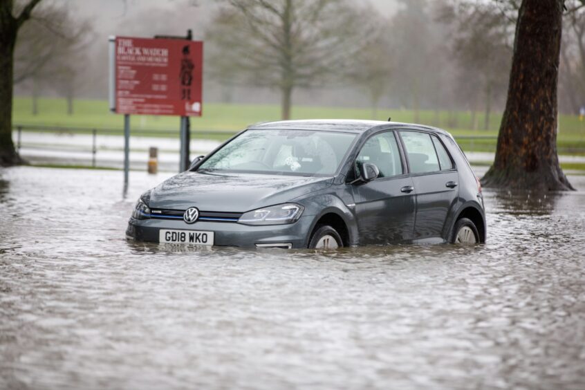 Car with water rising to near the top of its wheels in the Bell's Sports Centre car park