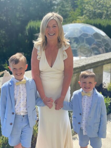 Lynda Mulholland pictured with her grandsons Adam and Rory at a friend's wedding. 