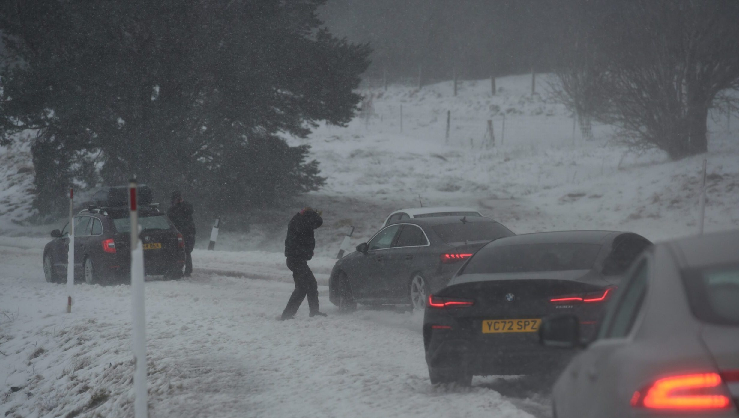 A person pushes their car in the snow on the A9 in Dalnaspidal.