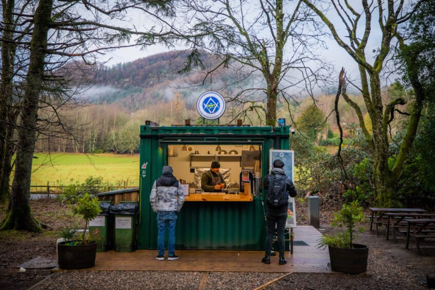 Craft Diner container with two customers waiting for food and a misty forest-covered mountain behind