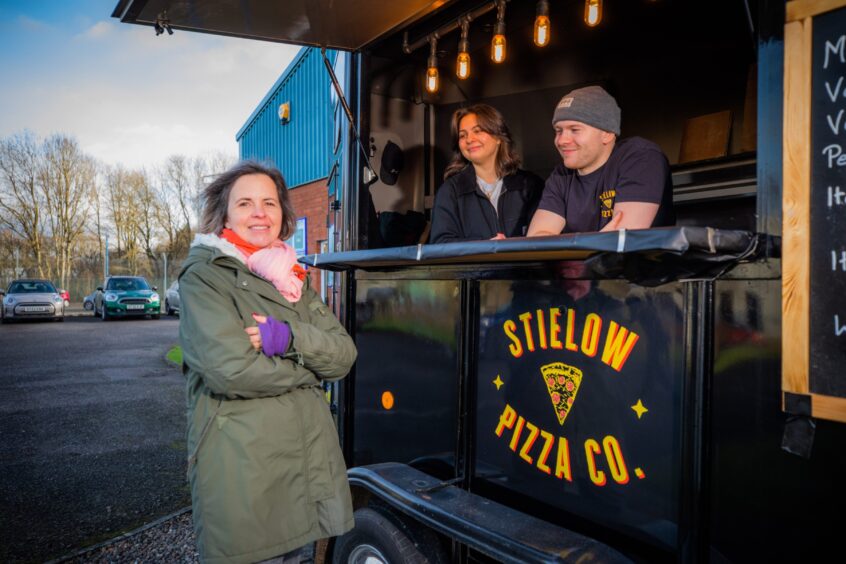Perth mum Esther is pictured with her two children at the family pizza van. 