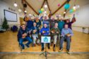 Members of the Auhterarder and District Men's Shed group holding up their ukuleles for the camera.