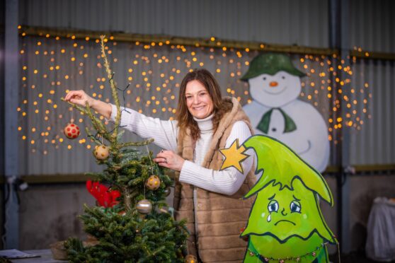 Kate Spurway decorating a wonky tree in a barn
