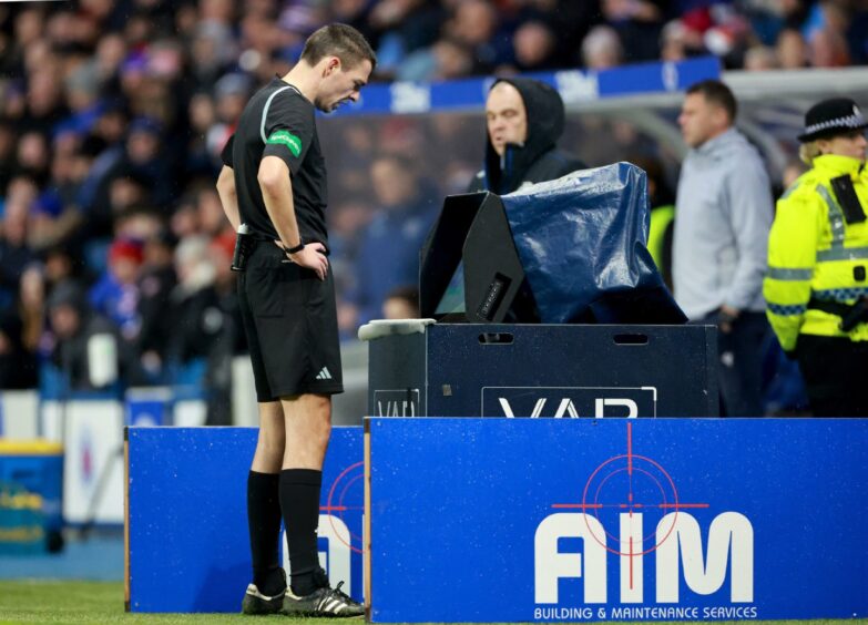 Referee Kevin Clancy goes to the VAR monitor at Ibrox. Image: PA