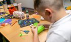 A Fintry pupil carefully constructs his surface design creation. Image: Steve Brown/DC Thomson.
