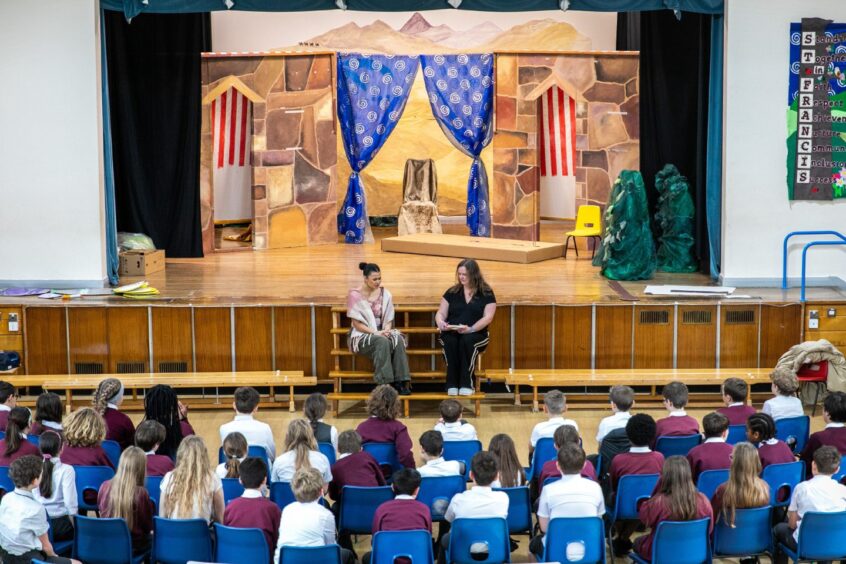 Image shows: actor Tinashe Warikandwa and feature writer Nora McElhone in front of an audience of Primary 6 and 7 pupils at Greyfriars Primary School in St Andrews. Tinashe is a former pupil of the school and visited to talk about her journey to becoming Cinderella at The Byre Theatre.