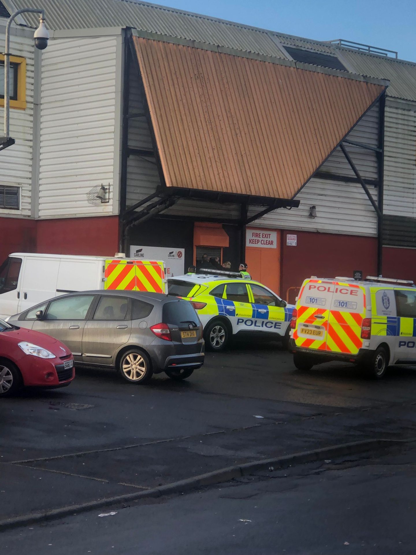 Police entering Tannadice Park on Sunday, with police vehicles parked outside Dundee United's stadium