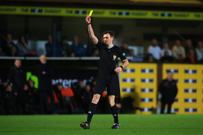 Referee Iain Snedden flashes a yellow card during Dundee United against Morton