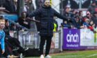 Dunfermline Athletic F.C. manager James McPake stretches out his arms on the sidelines during a game.