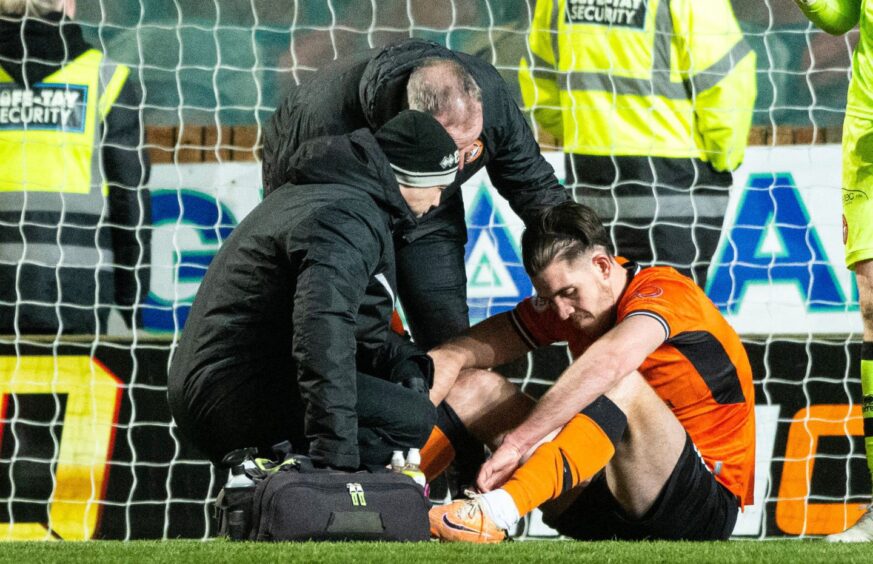 Declan Gallagher sits down as two physios treat him