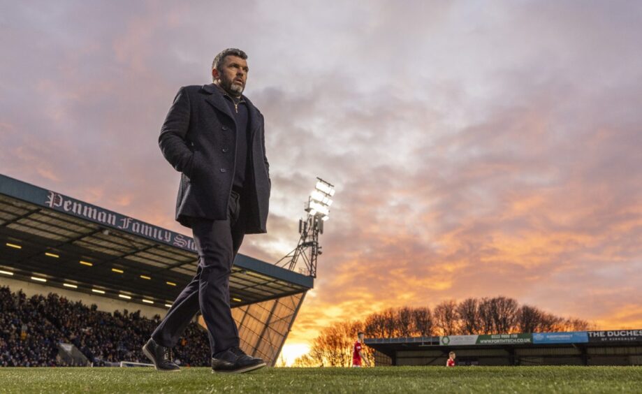Queen's Park manager Callum Davidson walks up the touchline at Stark's Park with a sunset in the distance. Image: Ross MacDonald / SNS Group.