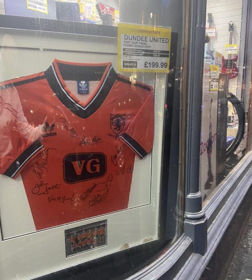 The signed Dundee United kit in Cash Converters shop window.