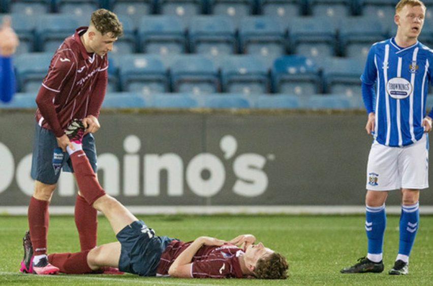 Dunfermline Athletic striker Taylor Sutherland helps brother Jake with some cramp during a youth match. Image: Craig Brown / DAFC.