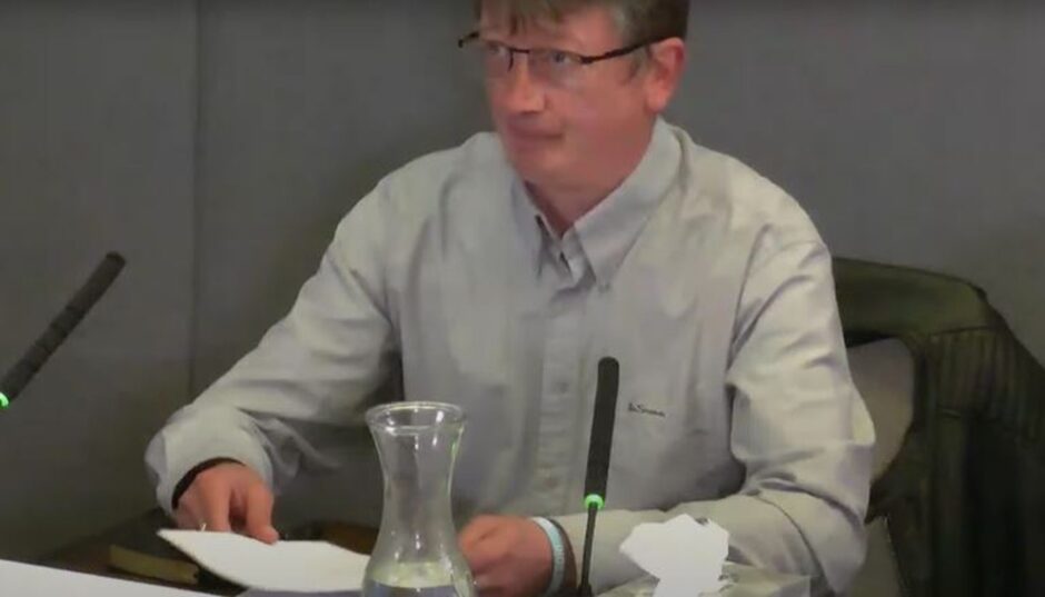 Chris Dawson at desk during evidence to post office inquiry