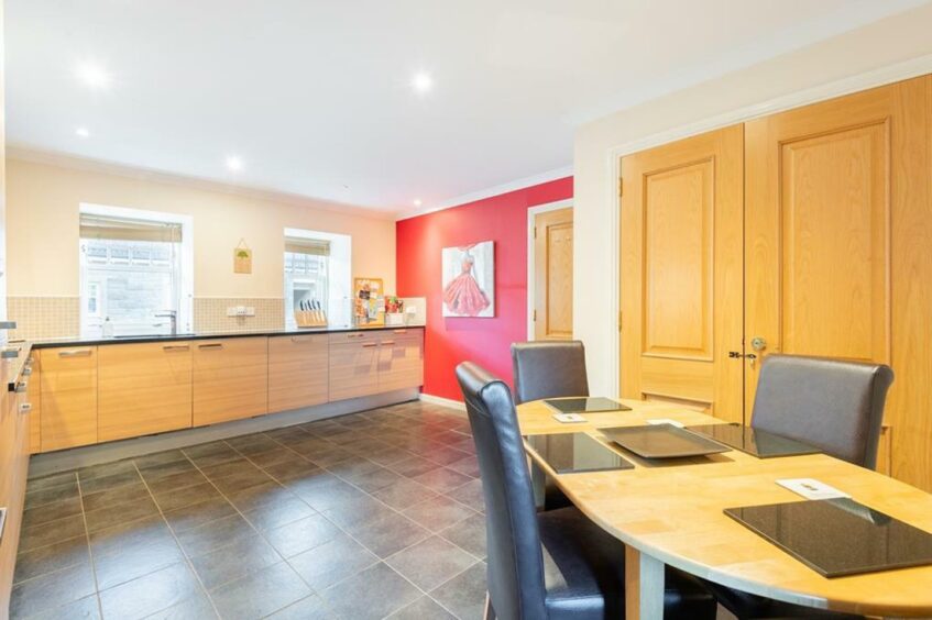 The modern kitchen is spacious and features integrated appliances. 