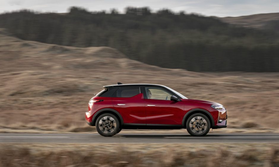 The DS 3 makes its way past trees and a field