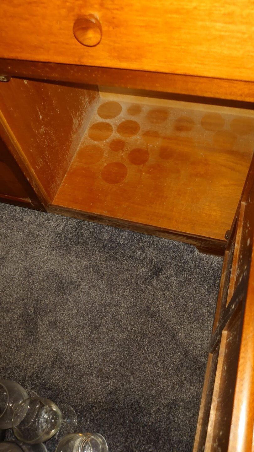The interior of a cupboard in Norman Hawkes' council house with circular marks where glasses have been standing in mould.
