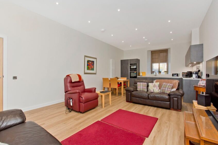 An open plan living/kitchen/dining room spans the length of the flat. 