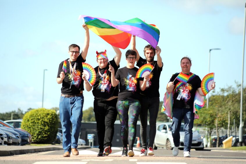 Nick Shane and fellow marchers wave rainbow fans and a large Pride flag at Dundee's first ever Pride march. 