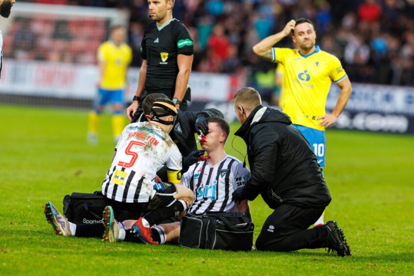 Chris Hamilton kneels in front of Dunfermline Athletic defender Sam Fisher as his team-mate gets treatment for a facial wound during the Fife derby defeat to Raith Rovers. Image: Kenny Smith/DC Thomson.