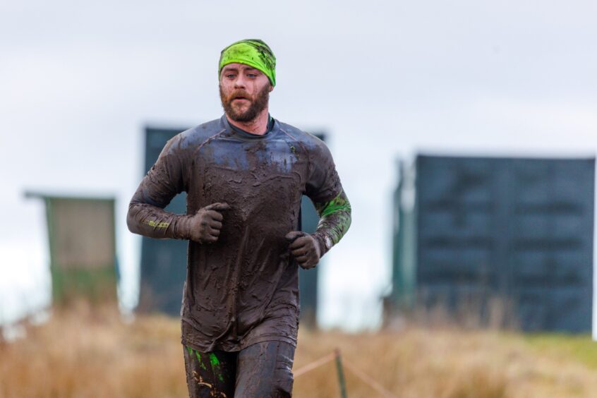 A very muddy runner.