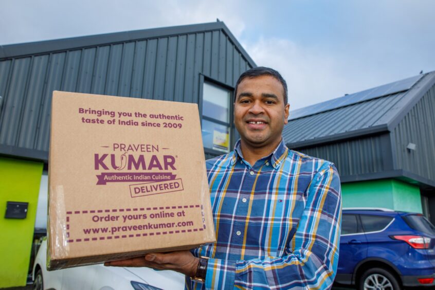 Perth chef Praveen Kumar stands at their unit holding one of their boxes of authentic Indian food, 