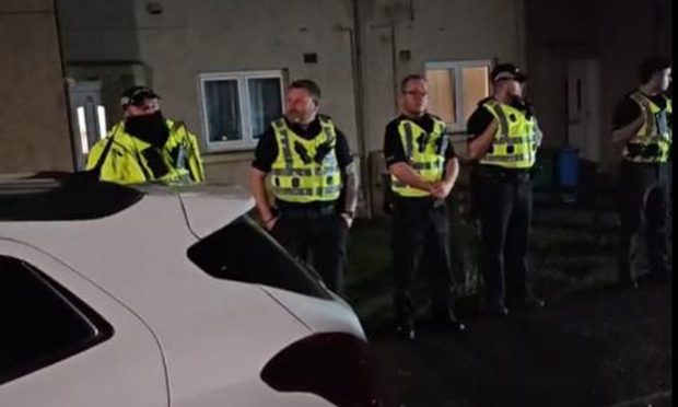 Officers outside the Kinglassie home during protest