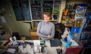 Marlene Wood behind Comrie post office counter