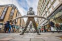 View of Perth High Street with well known 'leaning men' statue in foreground